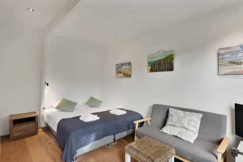 a bedroom with a bed and a couch and a chair at Dijkstra Hotels in Bergen