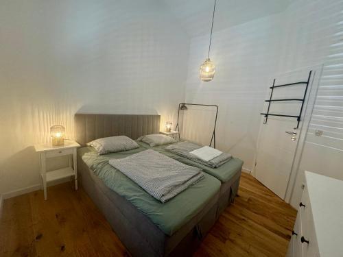 a bedroom with a bed and a table and lights at NINOA holidays in Petrcane