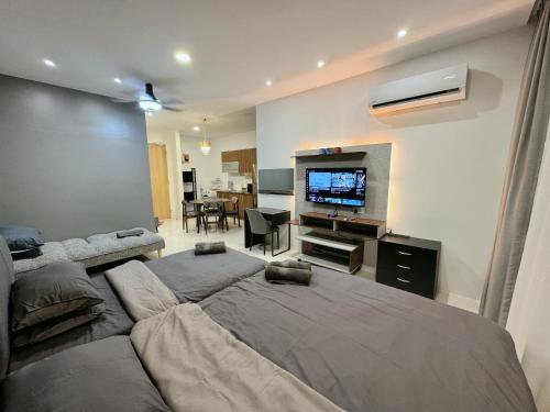 a bedroom with two beds and a flat screen tv at Kuching Cozy Comfort 03 - Riverine Diamond Kuching 5 Pax in Kuching