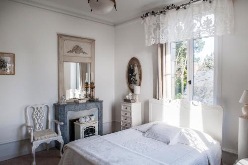 une chambre blanche avec un lit et une fenêtre dans l'établissement Maison d'Hôtes La Guérandière, à Guérande