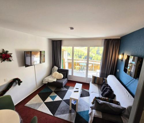ein Wohnzimmer mit Sofa und Tisch in der Unterkunft Résidence Les Terrasses d'Azur - maeva Home - Appartement 2 pièces 4 personnes Sélection MAE-6904 in Isola 2000
