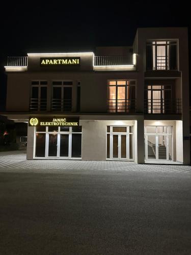 an apartment building at night with a sign on it at Janjić Apartmani in Zvornik