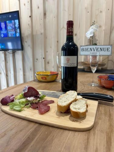 - une bouteille de vin assise à côté d'une assiette de nourriture dans l'établissement Studio cosy ambiance vosgienne à 20 mn de Gerardmer, à Lépanges-sur-Vologne