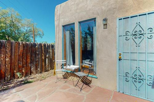 a patio with chairs and a blue door and a fence at Bedside Manor in Taos