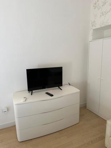 einen Flachbild-TV auf einer weißen Kommode in der Unterkunft RMG Home in Fisciano