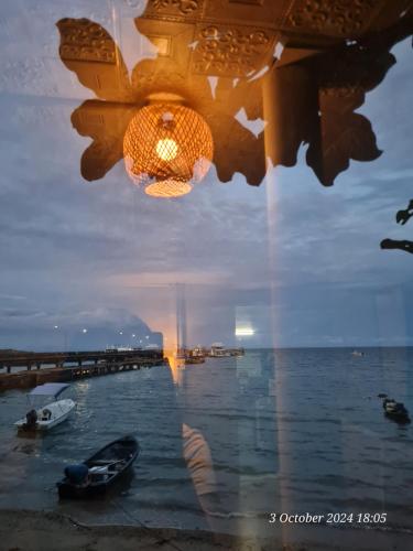 a reflection of a chandelier in a window with the water at The Hut Koh Mak Sea View in Ko Mak