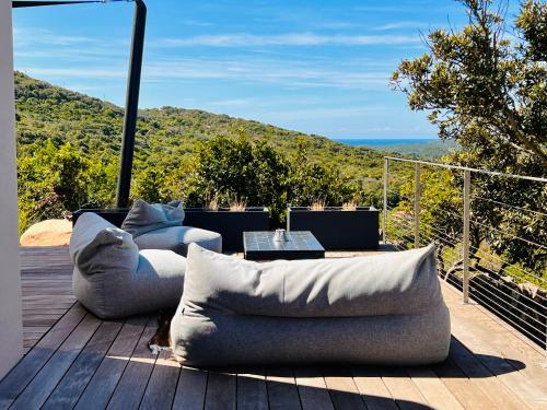 a living room with a couch and a table on a deck at Villa architecte vue mer et maquis in Figari