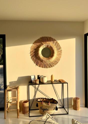 a room with a table with a mirror on the wall at Villa architecte vue mer et maquis in Figari