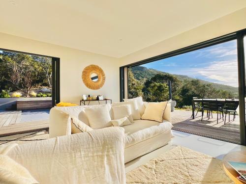 a living room with a couch and a large window at Villa architecte vue mer et maquis in Figari