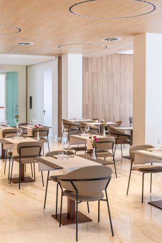 a restaurant with tables and chairs in a room at B&B HOTEL Habitat Giussano in Giussano