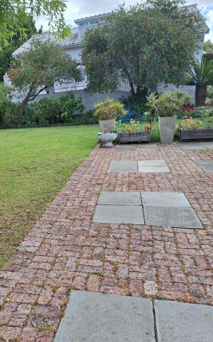 a brick walkway in a yard with some plants at House Forget Me Not in Bredasdorp