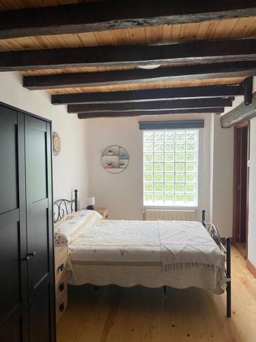 a bedroom with a bed and a window at Casa rural la Venta in Bareyo