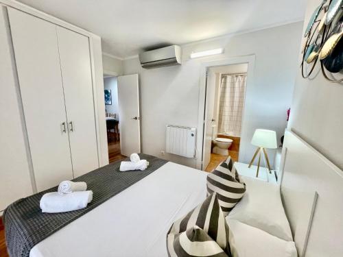a bedroom with a large bed with two towels at LA MER BLEUE, Boutique Apartament with free parking, full equipped in Fenals Beach in Lloret de Mar