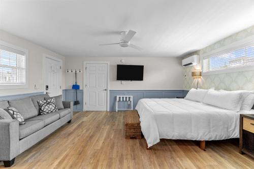 a bedroom with a bed and a couch and a tv at Loggerhead Inn and Suites in Surf City