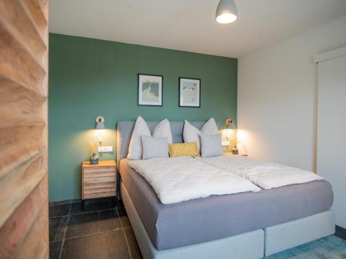 a bedroom with a large bed with a green wall at Brahmahof in Diex