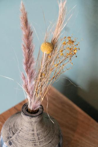 a vase with some dried plants in it on a table at Brahmahof in Diex