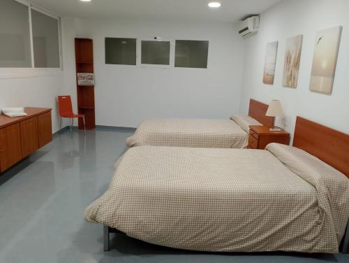 a room with two beds and a table and chairs at Apartamento Conde in Priego de Córdoba