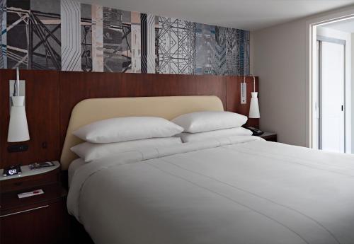 a bedroom with a large bed with white sheets and pillows at Marriott at the University of Dayton in Dayton