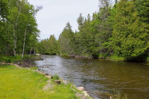 a river with trees on the side of it at River's Edge Hot tub dock trout fishing in Kingsley