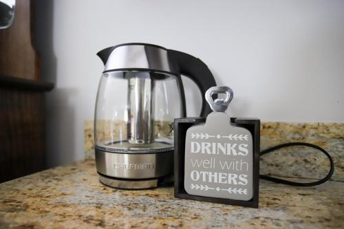 a drink well with others sign next to a blender at River's Edge Hot tub dock trout fishing in Kingsley