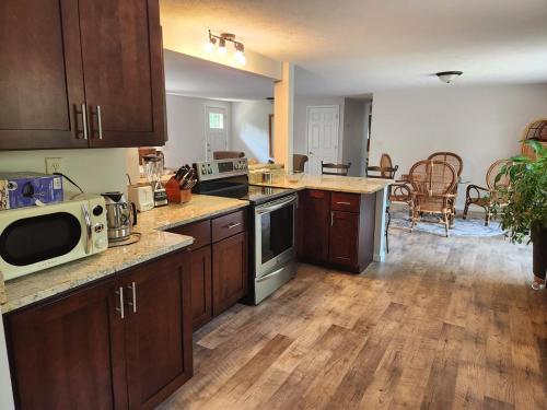 a kitchen with wooden floors and a kitchen with a microwave at River's Edge Hot tub dock trout fishing in Kingsley
