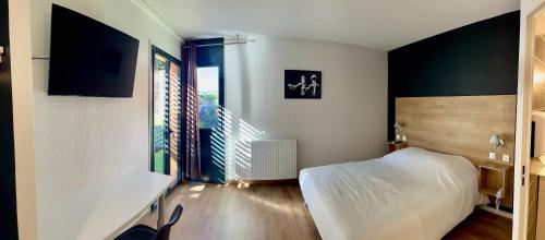 a bedroom with a white bed and a window at Les Cimes du Mont Royal in Montréjeau