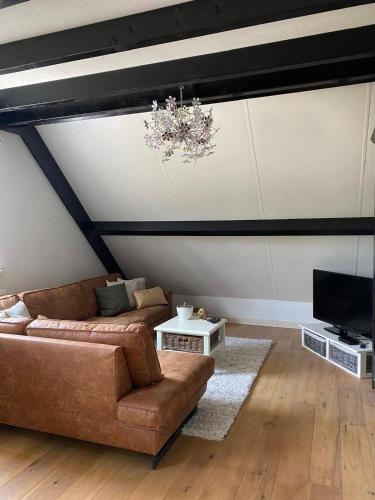 a living room with a couch and a tv at Toenders in Wintelre
