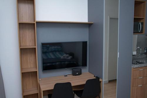 a room with a tv and a desk with chairs at ST Studios Vila Mariana by Housi in Sao Paulo