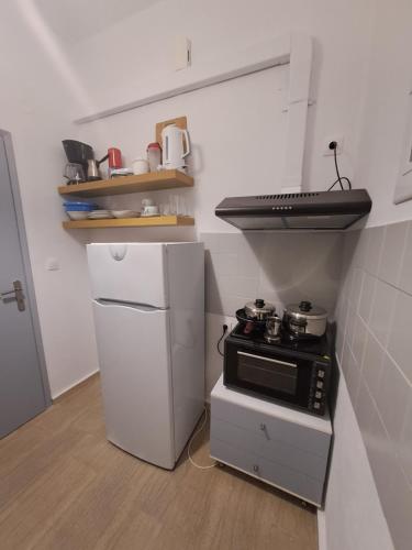 a small kitchen with a stove and a refrigerator at Studios Αποστόλης Selianitika in Aígio