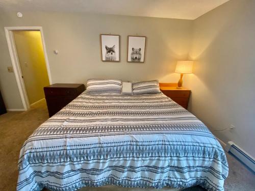 a bed in a bedroom with two pictures on the wall at Secluded Au Sable River Home in Grayling