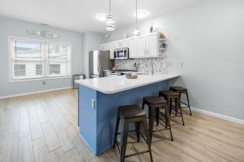 a kitchen with a blue island and stools at Beach Bliss in Wildwood Crest in Wildwood Crest