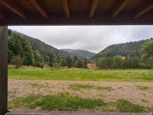 une vue sur un champ avec des montagnes en arrière-plan dans l'établissement Le studio des fondeurs, Mountain view, terrace, à La Bresse