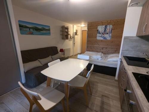 Ce petit appartement comprend une table et un lit. dans l'établissement Le studio des fondeurs, Mountain view, terrace, à La Bresse