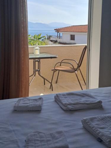 a bedroom with a bed and a table and a view of the beach at Studios Αποστόλης Selianitika in Aígio