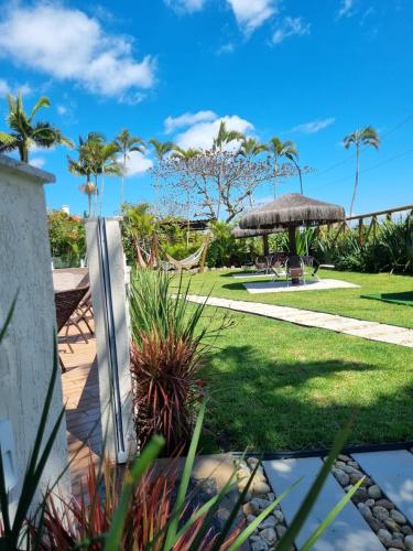 a garden with palm trees and a hammock at Apart Hotel Beira do Mar in Florianópolis