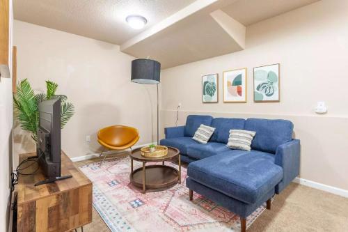 a living room with a blue couch and a tv at Family friendly 3 story townhouse with workspace in Beaverton