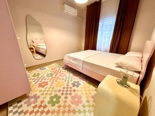 a small bedroom with a bed and a mirror at ALICE Daire in Konak