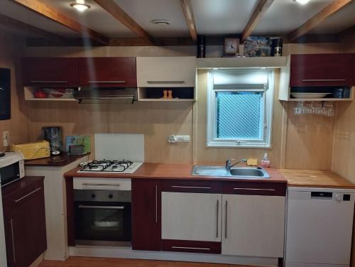 une petite cuisine avec un évier et une cuisinière dans l'établissement Chalet de vacances 5 couchages, à Saint-Cyr-en-Talmondais