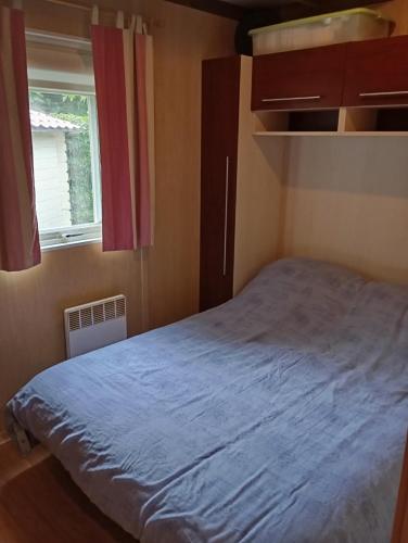 une petite chambre avec un lit et une fenêtre dans l'établissement Chalet de vacances 5 couchages, à Saint-Cyr-en-Talmondais