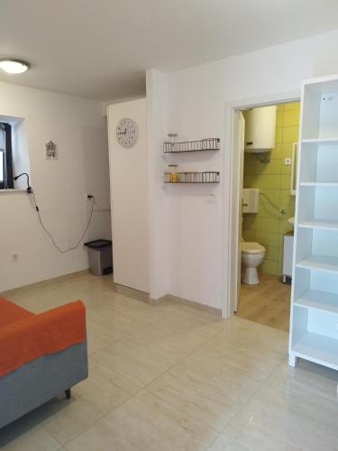 a living room with a toilet and a clock on the wall at Apartma Ela in Koper