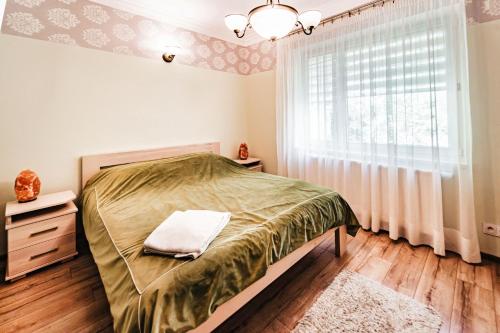 a bedroom with a bed and a window at Willa Poranek in Krynica Zdrój