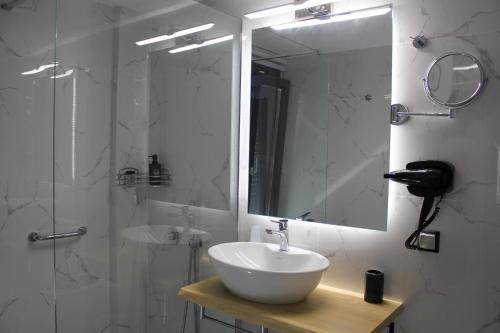 a bathroom with a sink and a mirror and a shower at Boutique apartments Myesis in Samothráki