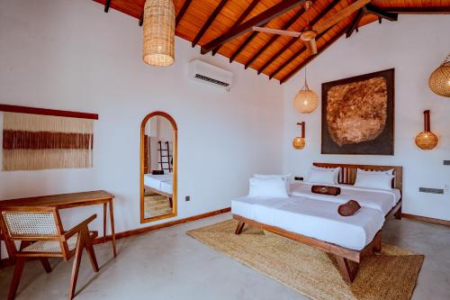 ウェリガマにあるThe Green Rooms Surf & Yoga Camp - ON THE BEACH - Prime location Renovated 2024のベッドとテーブルと椅子のある寝室