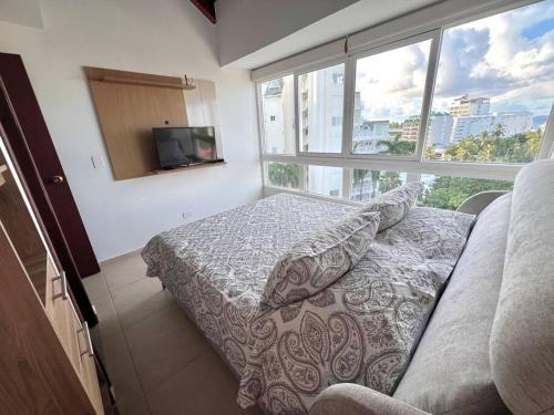 a bedroom with a bed and a large window at Bestview SAI704 in San Andrés