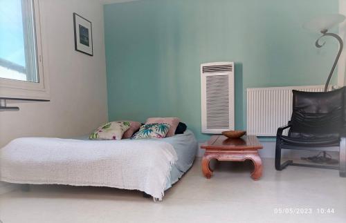 une chambre avec un lit, une chaise et une table dans l'établissement La cahute, studio avec cour extérieure, à Montauban
