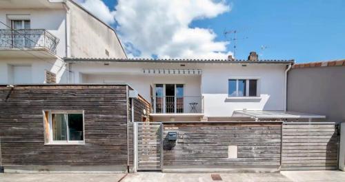 une maison avec une clôture en bois devant elle dans l'établissement La cahute, studio avec cour extérieure, à Montauban