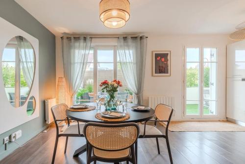 a dining room with a table and chairs and windows at Agapé by Kleidos -Disney à 10min, T2 , 4P, Parking gratuit et terrasse in Magny-le-Hongre