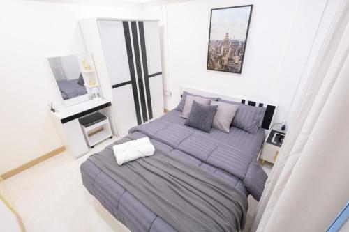 a bedroom with a large bed with purple sheets and pillows at Cozy & Affordable apartment in Chiang Mai in Chiang Mai