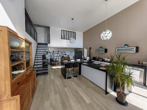 Il comprend une cuisine ouverte et un salon avec un escalier. dans l'établissement Loft en Champagne proche Reims, à Courcy