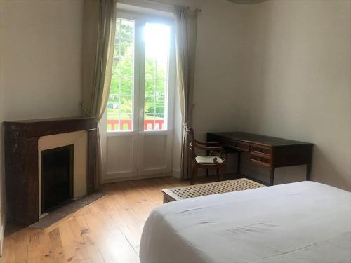 Un dormitorio con una cama y un escritorio y una ventana. en Bel appartement avec vue, en Hendaya